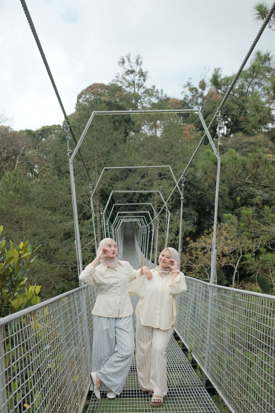 Pengunjung berdiri di jembatan gantung di tengah hutan pinus, D'Glorius Kamodjang