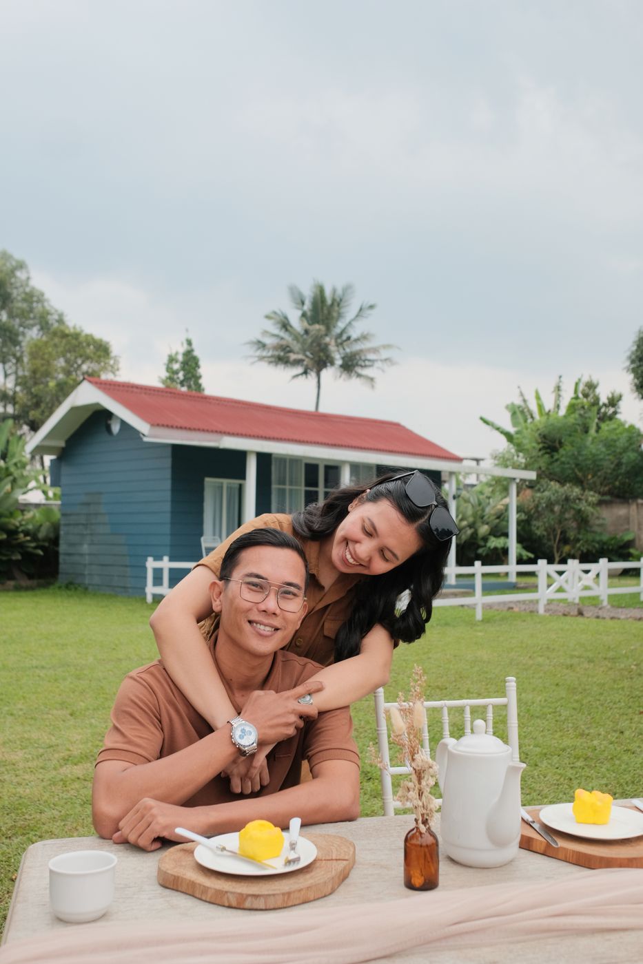 Pasangan piknik di halaman rumput dengan latar barn putih, Garland Barnville